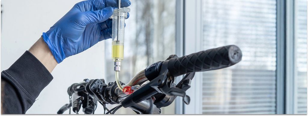 Detailaufnahme Hand, die eine hydraulische Scheibenbremse entlüftet