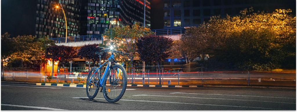 Ein E-Mountainbike steht nachts an einer Straße