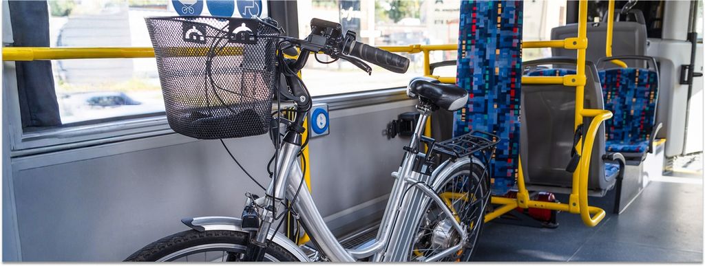 Ein Fahrrad mit Korb am Lenker steht in einem Bus des Nahverkehrs