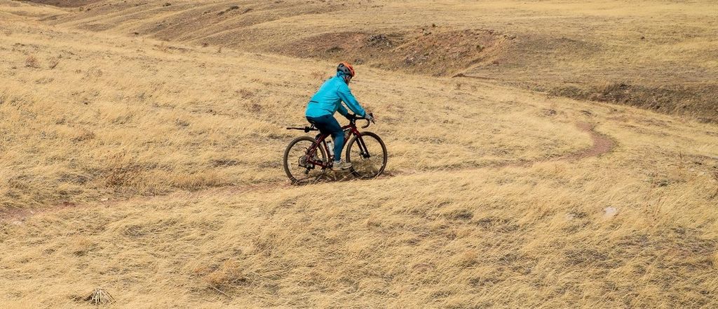 Male cyclist is riding a gravel bike on a single track trail in Colorado foothills in early spring scenery, Soapstone Prairie Natural Area